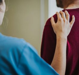 Female nurse touching a patients shoulder