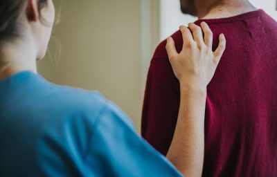 Female nurse touching a patients shoulder
