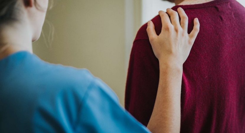 Female nurse touching a patients shoulder