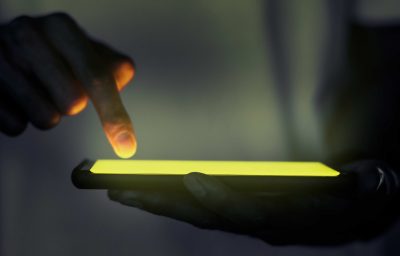 Hand touching illuminated smartphone screen