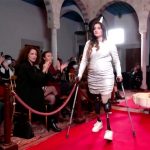 model with disability walking on red carpet