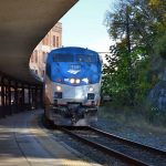An Amtrak passenger train pulling into the station with an outdoor platform