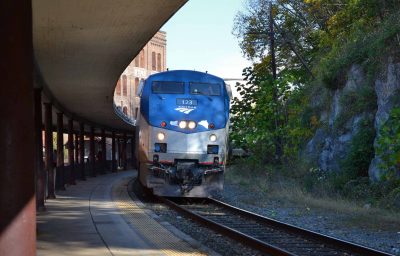 An Amtrak passenger train pulling into the station with an outdoor platform