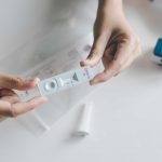 Woman using a covid-19 self test rapid antigen testing kit at home