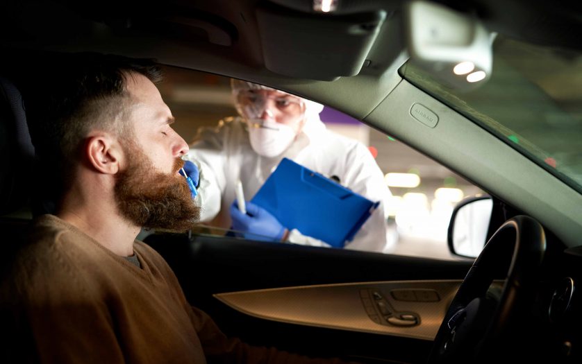 Medical worker performing drive-thru COVID-19 test