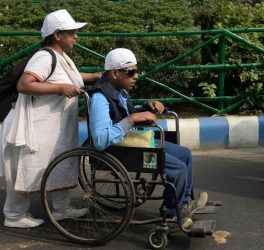 woman pushing a person in wheelchair during a rally in Calcutta, India.