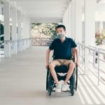 child in wheelchair wearing mask