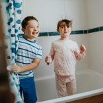 Sister and brother playing peekaboo in the bathroom