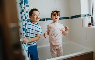 Sister and brother playing peekaboo in the bathroom
