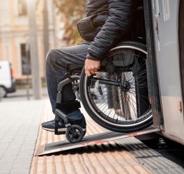 wheelchair user exits public transport with accessible ramp