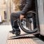 wheelchair user exits public transport with accessible ramp