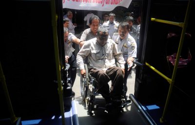 Wheelchair user boarding public transportation specifically designed in Solo , Central Java , Indonesia