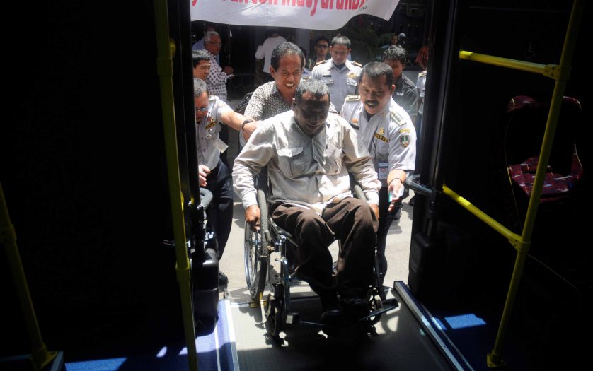 Wheelchair user boarding public transportation specifically designed in Solo , Central Java , Indonesia
