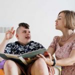Cerebral palsy boy talking with woman therapist