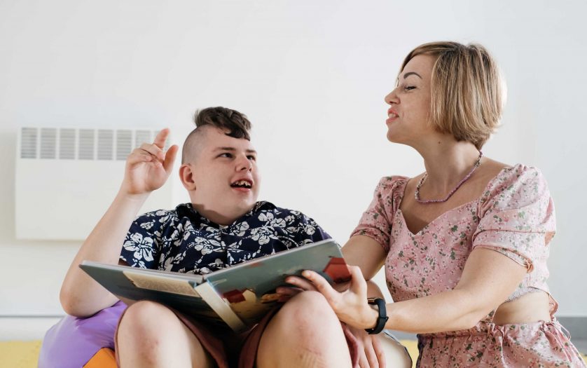 Cerebral palsy boy talking with woman therapist