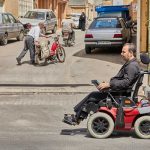 Man in electronic wheelchair in the street