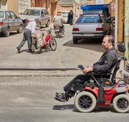 Man in electronic wheelchair in the street