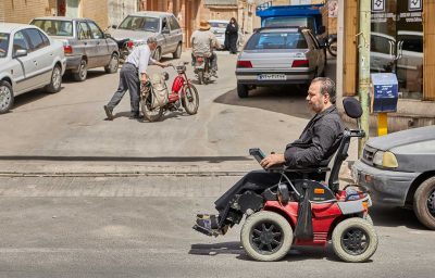 Man in electronic wheelchair in the street
