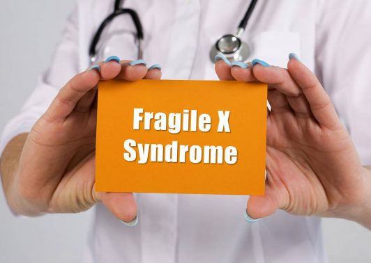 doctor holding Fragile X syndrome card