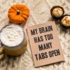 My brain has too many tabs open notebook alongside a pumpkin, cupcakes and a mug.