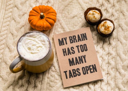 My brain has too many tabs open notebook alongside a pumpkin, cupcakes and a mug.