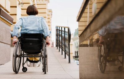 woman in wheelchair entering in a building