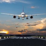 Airplane landing in the evening with beautiful sunset background