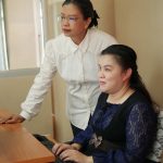 blind woman with her colleage working in the office