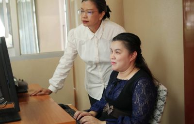 blind woman with her colleage working in the office