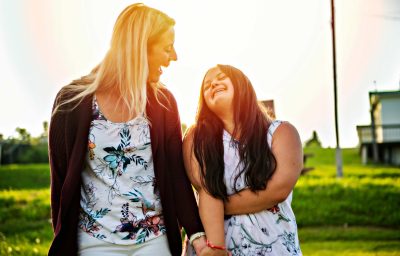 adult girl smilin outside at sunset with family friend
