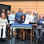 New York Governor Kathy Hochul shows a signed package bill with a group