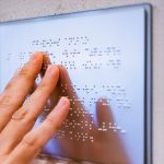 blind person reading braille board