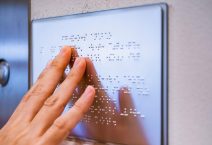 blind person reading braille board