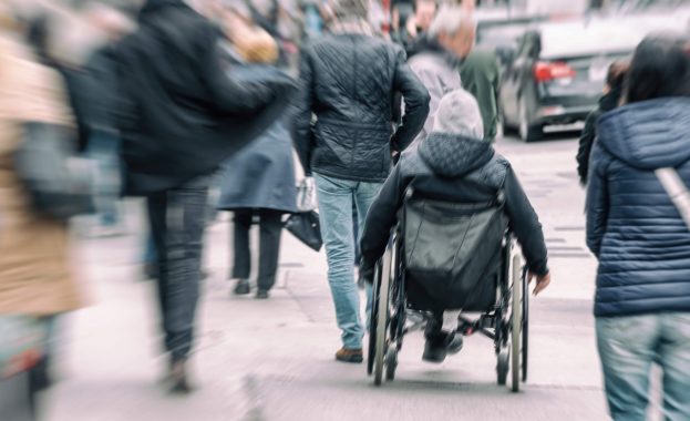 man in a wheelchair on a busy street