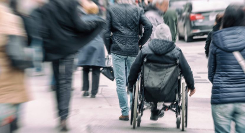 man in a wheelchair on a busy street
