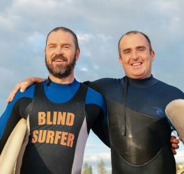 blind surfer with trainer