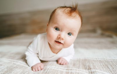 Cute baby ginger hair close up crawling on bed