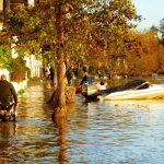 people on flooded street, inclusing a wheelchair user