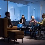 Businesswoman in wheelchair having business meeting with team at office
