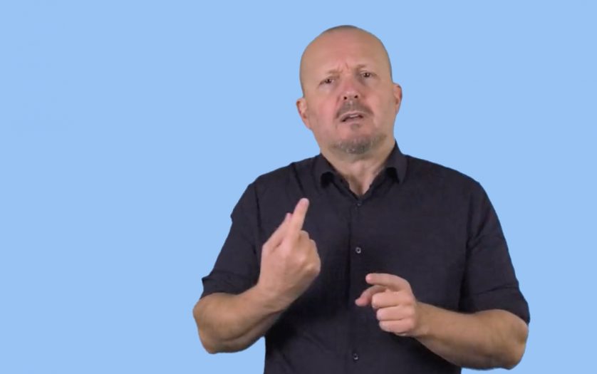 man using sign language on light blue background