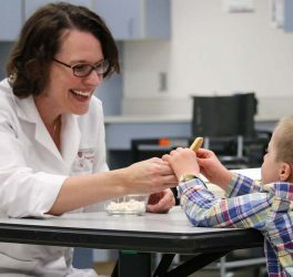Carolyn Ross works with a child with Down syndrome on the food texture study.