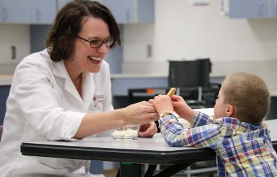 Carolyn Ross works with a child with Down syndrome on the food texture study.