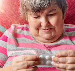 woman with intellectual disability is looking at some of her pills