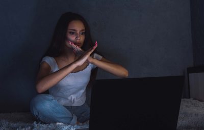 teen girl in the dark room with notebook, with cross hands