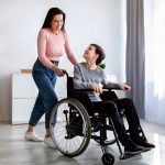 mother with son in wheelchair at home