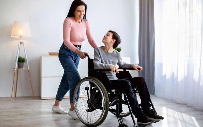 mother with son in wheelchair at home