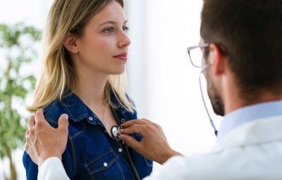 doctor using stethoscope to examine patient.