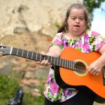 woman with down syndrome playing guitar