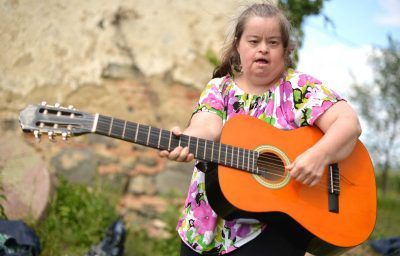 woman with down syndrome playing guitar