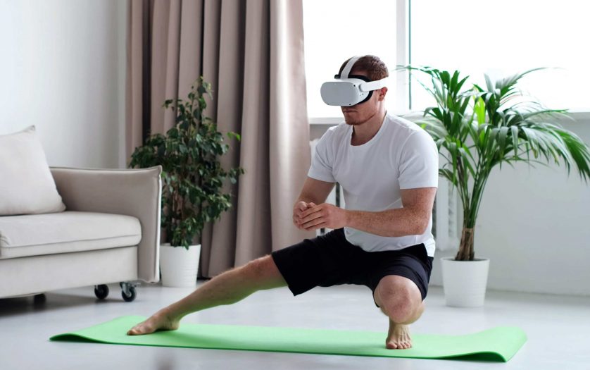Man doing squat while wearing virtual reality glasses.